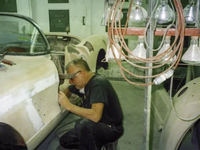 Corvette Connection technician sanding 1958 Corvette body during primer stage