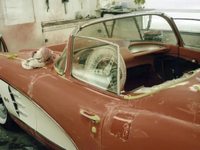 Side view of finished red and white 1958 Corvette parked outside Corvette Connection