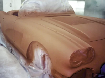 Rear deck of 1958 Corvette body in red paint with cove section masked at Corvette Connection