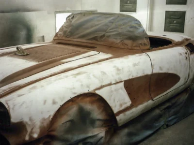 Front three-quarter of 1958 Corvette body in red primer with hood off at Corvette Connection