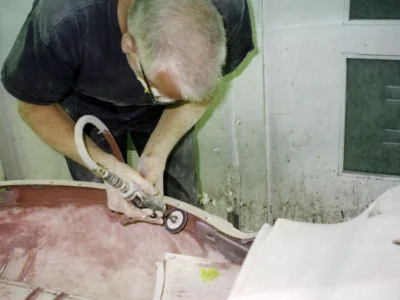 Corvette Connection technician color-sanding 1958 Corvette body during finishing stage