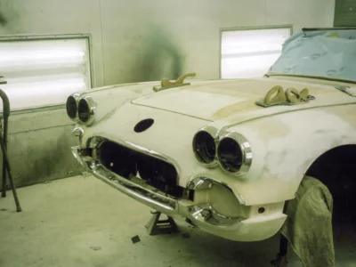 Front view of 1958 Corvette in primer with empty headlight bezels at Corvette Connection