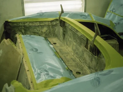 Interior tub of 1958 Corvette with green-tinted primer during bodywork stage