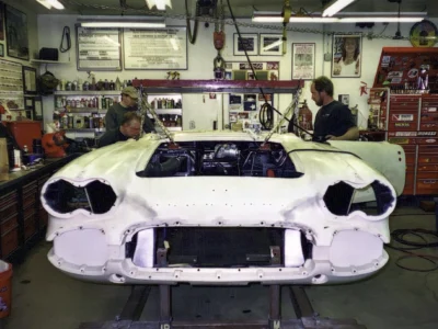 Front three-quarter of 1962 Corvette body in primer with empty headlight bezels