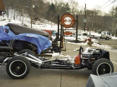 1962 Corvette body lowered onto restored chassis outdoors at Corvette Connection