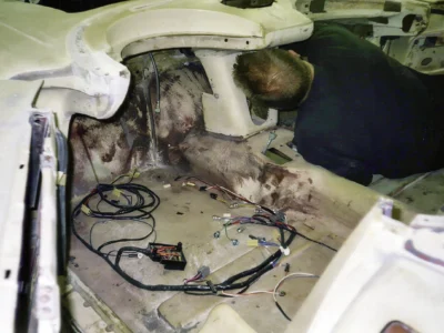 Corvette Connection technician working inside 1962 Corvette body shell during reassembly