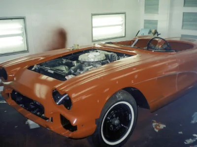 Front three-quarter of red 1962 Corvette during chrome trim reinstallation