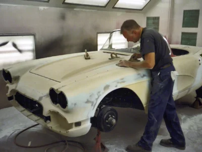Corvette Connection technician sanding 1962 Corvette front fender during paint prep