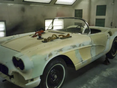 Side profile of 1962 Corvette body in primer-sealer with masking inside paint booth