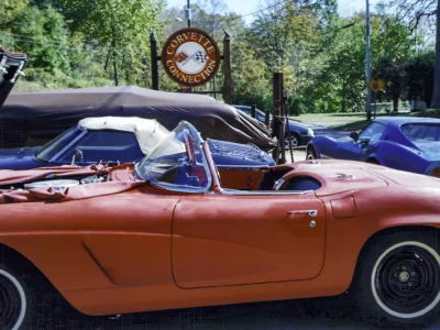 Side profile of finished red 1962 Corvette parked outdoors at autumn car show