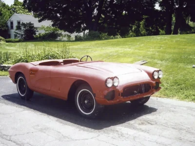 Front three-quarter of finished red 1962 Corvette parked outdoors at residence