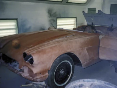 Side profile of 1962 Corvette body in red paint inside Corvette Connection paint booth
