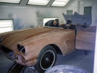Front three-quarter of 1962 Corvette body in red paint inside paint booth