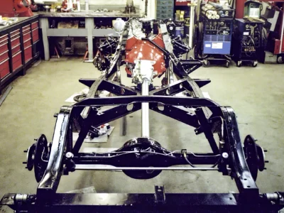 Front view of 1962 Corvette rolling chassis with red engine and front suspension assembled