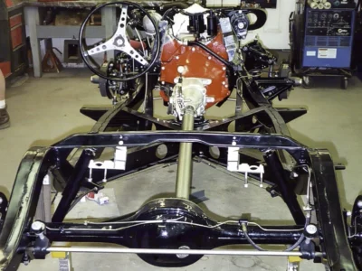 Front view of 1962 Corvette rolling chassis with red engine and front suspension assembled