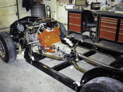1968 Corvette body on chassis with orange engine visible during assembly at Corvette Connection