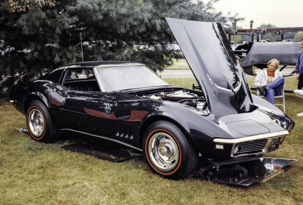 Restored 1968 Corvette Stingray in black with hood up showing engine at car show