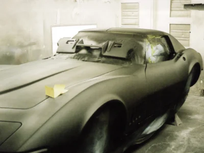 Side view of a 1968 Corvette in primer with bodywork in progress
