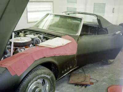 1968 Corvette with red primer and body filler on the front fender during restoration