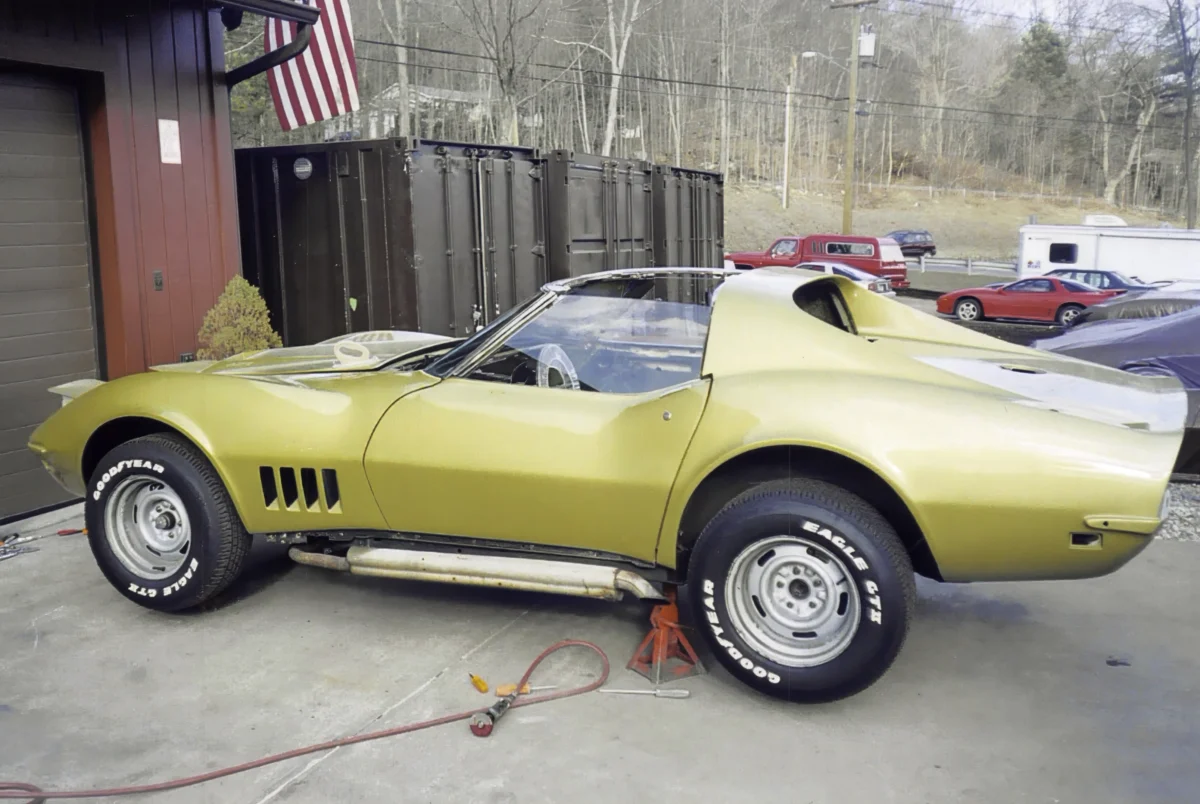Gold 1969 Corvette convertible on jack stands during restoration.
