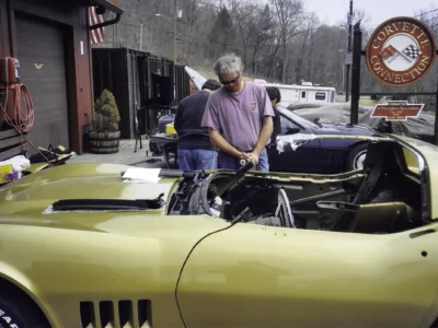Technician working on a gold 1969 Corvette convertible inside Corvette Connection in Bolton, CT.