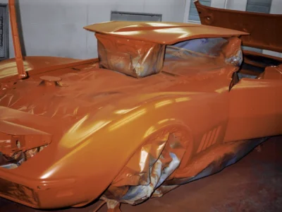 1969 Corvette Stingray body in fresh red paint with masking still on during paint process
