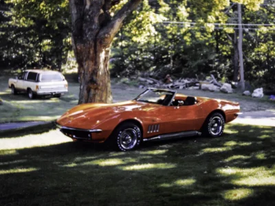 Completed 1969 Corvette Stingray convertible in red under tree outdoor beauty shot at Corvette Connection in Bolton CT