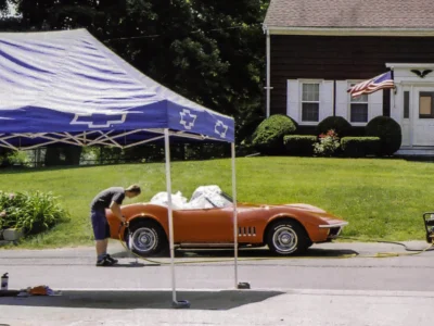 Restored 1969 Corvette Stingray convertible in red on display under tent at car show