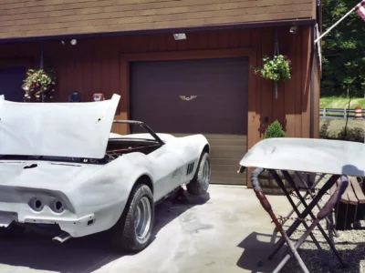 White 1969 Corvette parked outside the shop during restoration