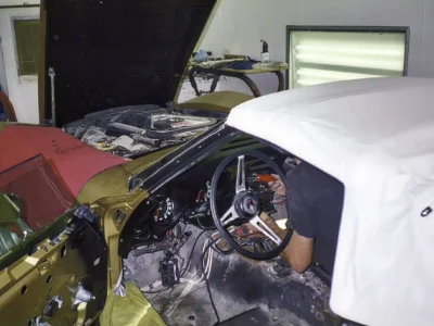 1969 Corvette engine bay and white convertible top area during assembly.