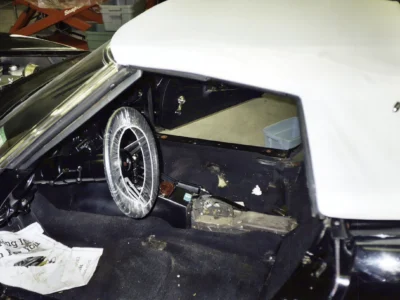 Black 1969 Corvette interior with white convertible top during disassembly.