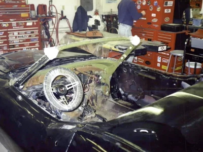 1969 Corvette interior stripped for restoration with steering wheel and dashboard exposed.