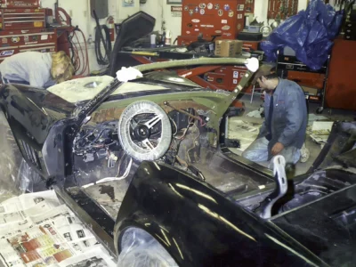 Technician working inside the stripped interior of a 1969 Corvette.