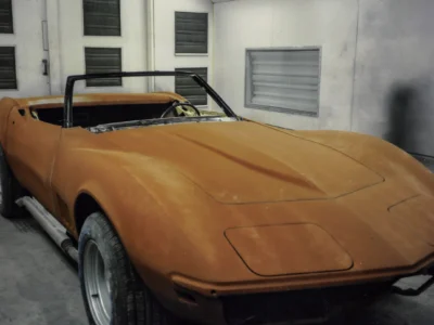 1969 Corvette Stingray convertible in orange primer rear view in paint booth