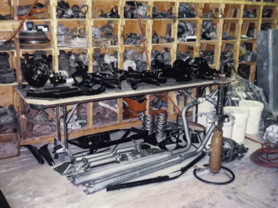 1969 Corvette chassis components and suspension parts organized on rack at Corvette Connection