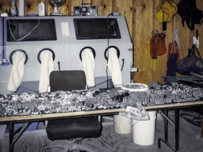 1969 Corvette exhaust manifolds and intake components on workbench at Corvette Connection