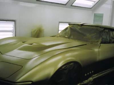 Gold 1969 Corvette body inside the paint booth after paintwork.