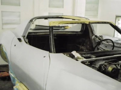 White 1969 Corvette in the shop with hood open and engine bay exposed.