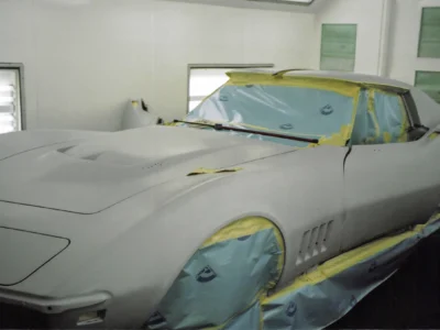 1969 Corvette front body section in light primer with windshield masked.