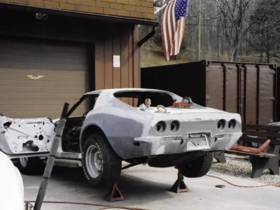 White 1969 Corvette body shell on stands outside the shop.