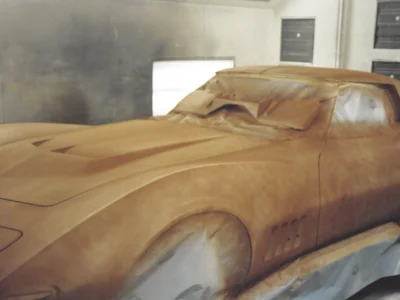 1969 Corvette body in red primer during early paint preparation.