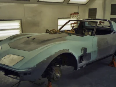 1970 Corvette body in light primer inside the shop during paint preparation.