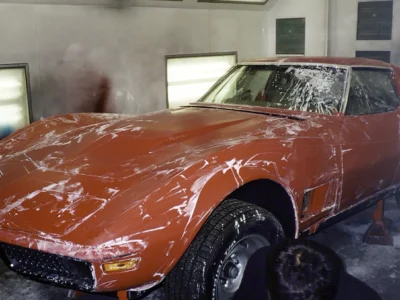 Red 1970 Corvette front fender and hood area during final paintwork.