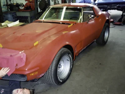 1970 Corvette in red primer parked inside the restoration shop.