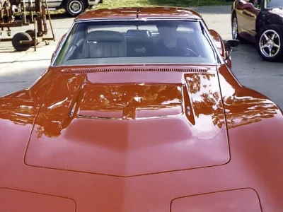 Front view of finished red 1970 Corvette showing hood, headlights, and front emblem