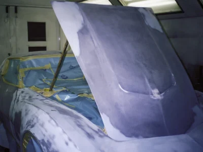 1970 Corvette hood raised during primer and bodywork preparation.