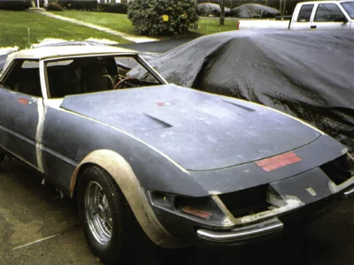 McBurnie Daytona Spyder in primer with cover partially on outdoors at Corvette Connection