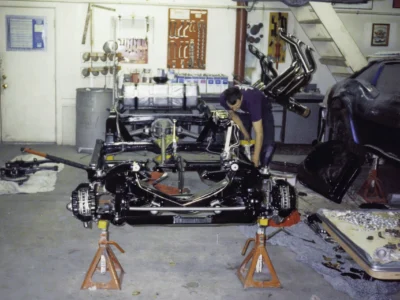 Technician working on McBurnie Daytona Spyder engine and chassis assembly at Corvette Connection