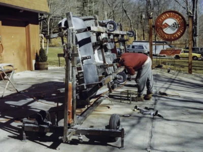Technician working on McBurnie Daytona Spyder body outdoors at Corvette Connection in Bolton CT