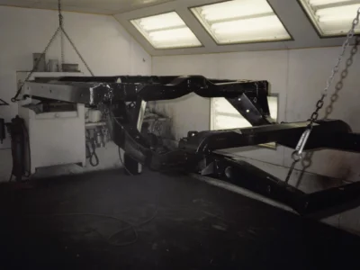 McBurnie Daytona Spyder C3 frame in black paint in paint booth at Corvette Connection